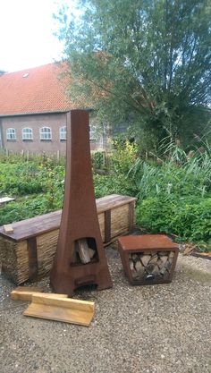 a wooden bench sitting in the middle of a garden next to a firewood log