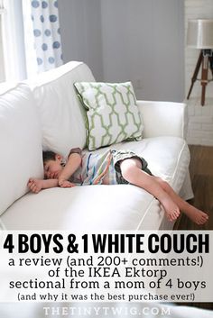 a young boy laying on top of a white couch in a living room next to a window