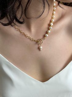 This unique necklace combines classic and modern design elements, creating an elegant and distinctive look. One half of the necklace features natural pearls and beads, coated with 18-karat gold, adding a touch of sophistication and luxury. The other half is a chain, also coated with 18-karat gold, adding a modern accent and completing the look. Features: Materials: Natural pearls, beads, and chain coated with 18-karat gold. Design: The combination of pearls and the gold chain creates a stylish c Pearl Lariat Necklace With Chain, Elegant Toggle Necklace With Delicate Chain As Gift, Lariat Pearl Necklace With Clavicle Chain, Pearl Lariat Necklace With Clavicle Chain As Gift, Lariat Pearl Necklace With Clavicle Chain As Gift, Everyday Elegant Lariat Necklace With Clavicle Chain, Elegant Toggle Chain Necklace With Pendant, Elegant Pendant Toggle Necklace With Chain, Elegant Pendant Lariat Necklace With Lobster Clasp