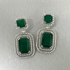 The Renee Emerald & Diamond Earrings are a unique and luxurious heritage pair with royal green emeralds and diamonds set in white gold. Gemstones Type: EmeraldGemstones Shape: RectangularGemstones Weight: 25.01 ctGemstones Color: Green Diamonds Shapes: Round & Marquise Total Diamonds Weight: 3.01 ctDiamonds Color: H - J Diamonds Clarity: VS - SI (Very Slightly Included - Slightly Included) Metal: 14K Gold Metal Wt: 17.4 gms Setting: Prong Set Price Quoted may be negotiable. Please contact us to Green Diamond Earrings With 17 Jewels For Formal Events, Green Diamond Earrings With 17 Jewels For Formal Occasions, Luxury Green Diamond Earrings, Emerald Diamond Earrings For Formal Occasions, Luxury Emerald Earrings With Diamond Accents, Emerald Diamond Earrings For Formal Events, Formal Emerald Diamond Earrings, Luxury Green Diamond Earrings With Accents, Formal Emerald Earrings With Diamond Accents