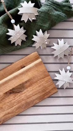 wooden cutting board with snowflakes on it next to green napkin and other decorations