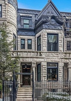 an old building with many windows and wrought iron gated entry way leading to the front door