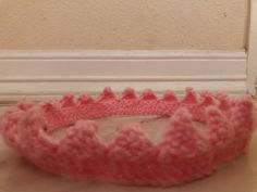 a pink crocheted basket sitting on top of a counter next to a door