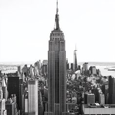 black and white photograph of the empire building in new york city, from top of the rock