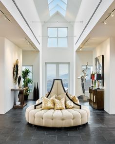 a large living room with high ceilings and floor to ceiling windows