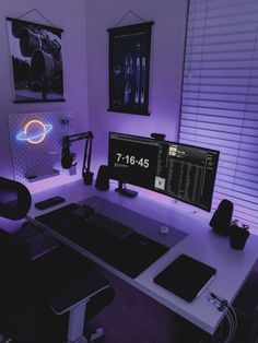 a computer desk with two monitors and speakers on it in front of a purple light