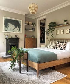 a bedroom with a bed, dresser and plants