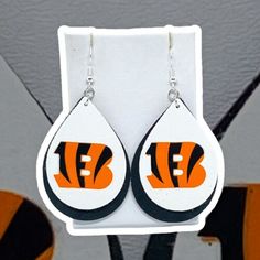 a pair of earrings with the nfl logo on it and tears hanging from them