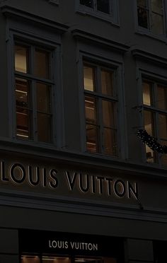 the storefront of louis vuitton is lit up at night with its lights on