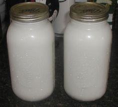 two white mason jars sitting next to each other