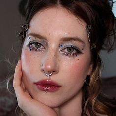 a woman with blue and white glitters on her face is posing for the camera