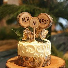 a wedding cake is decorated with wood slices and mr and mrs topper on it