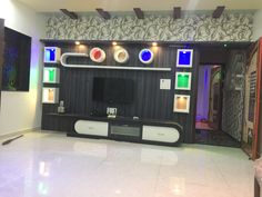 a living room with a large tv on the wall and colorful glass windows above it