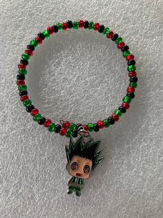 a beaded bracelet with a charm on it and a small cartoon character in the middle