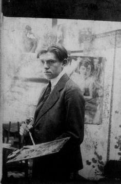 an old black and white photo of a man in a suit holding a paintbrush