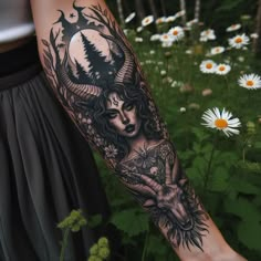 a woman's arm with a tattoo on it in front of flowers and daisies