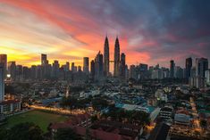 the city skyline is lit up at sunset