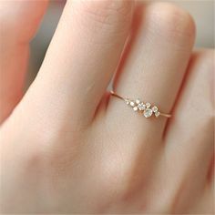 a woman's hand with a diamond ring on top of her finger and the other hand holding it