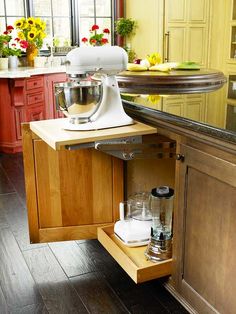 an open cabinet in the middle of a kitchen with flowers on the counter and appliances