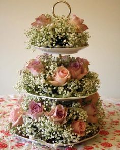 three tiered cake with pink roses and baby's breath flowers on the top