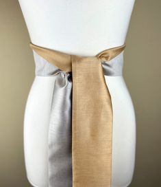 "Wide Textured Gold &  Silver Sash Belt  Silver and Gold Dupioni Sash  Two-Tone Dress Sash  Fabric Belt  Silver Gold Wedding  Add sophistication and rich texture to your special occasion outfit with this two-tone Satin Swank® dupioni waist sash. Depending on your waist size and the length you choose (75 and 90 inch lengths available), you can wrap this sash around your waist once or twice. You decide whether to tie the sash in a bow or a simple knot with long-hanging tails. Tie in front, in back Elegant White Luxury Sashes, Elegant Fitted Sash With Tie Back, Elegant Fitted Sashes With Tie Back, Formal Fitted Sash With Tie Back, Elegant Fitted Sashes With Matching Belt, Silver Gold Wedding, Occasion Outfit, Waist Sash, Dress Sash