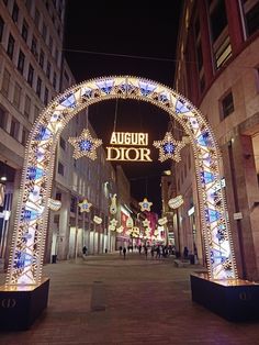 an archway decorated with lights in the middle of a street