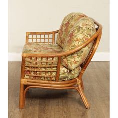 a bamboo chair with floral upholstered fabric on the armrests and back