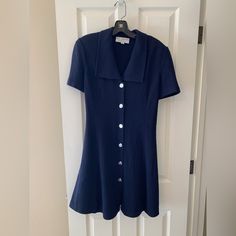 Pre-Loved Vintage St. John Collection By Marie Gray, Navy Blue Short Sleeve Dress. Classic St. John Sweater Knit, With Button-Front Closure. 6 Silver St. John Buttons. Knee-Length With Slight Flare To Hem For Fuller Look. Made In Usa, Dry Clean Only. No Visible Stains, Snags Or Damage-Mint Condition! Recently Dry-Cleaned. Measurements: Nape To Hem-37” Shoulder Seam To Shoulder Seam-16.5” Armpit To Armpit-19” Blue Knee-length Mini Dress With Button Closure, Classic V-neck Mini Dress With Buttons, Blue V-neck Mini Dress With Button Closure, Blue Mini Dress With Button Closure And Short Sleeves, Fitted Navy Dress With Buttons, Blue Mini Dress With Buttons And Short Sleeves, Elegant Blue Mini Dress With Button Closure, Classic Short Sleeve Mini Dress With Buttons, Blue Fitted Button-up Mini Dress