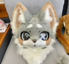 a stuffed animal cat sitting on top of a chair