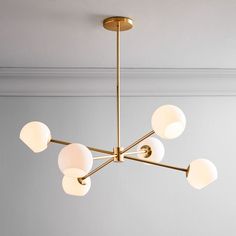 a chandelier hanging from the ceiling in a room with white walls and light fixtures