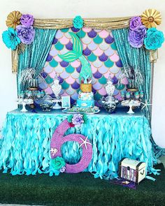 a mermaid themed birthday party with blue and purple decorations, under the sea theme table