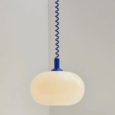 a blue and white light hanging from a ceiling fixture with a spiral design on it