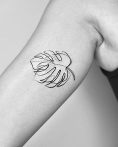 a black and white photo of a woman's arm with a tattoo on it