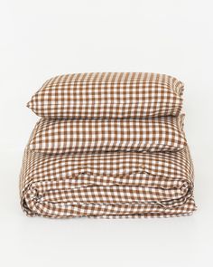 the brown and white checkered sheets are folded up on top of each other,