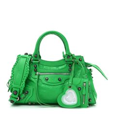 This is an authentic BALENCIAGA Agneau Arena Small Neo Cagole City Handbag in Vivid Green. This stylish tote is beautifully crafted of textured lambskin leather in green. It featurestop handles with a woven detail and a leather shoulder strap. This bag also features the signature Balenciaga look of a front zipper pocket with decorative silver hardware including buckles and studs. The top zipper opens to a black fabric interior with a zipper pocket. Designer Green Satchel With Top Carry Handle, Designer Green Bag With Removable Pouch, Designer Green Bags With Removable Pouch, Designer Green Shoulder Bag With Handles, Designer Green Satchel For Daily Use, Luxury Green Shoulder Bag With Double Handle, Designer Green Satchel With Detachable Handle, Designer Green Satchel Bag, Designer Green Leather Shoulder Bag