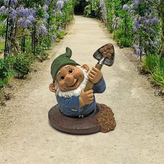 a garden gnome statue holding a shovel on a path