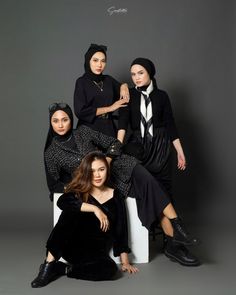 four women in black outfits posing for a photo