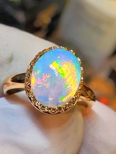 If you like a tropical sunset colors, or if your favorite color is blue you'll like this stone,  10x12mm  4.09cts  mounted on a 14k solid gold gallery style bezel ring. Round Opal Ring, Heirloom Opal Cabochon Ring, Heirloom Cabochon Opal Ring, Heirloom 14k Gold Opal Ring Oval Cabochon, Yellow Gold Opal Cabochon Ring, Yellow Gold Opal Ring With Cabochon, Ethiopian Opal Oval Cabochon Ring In Yellow Gold, Yellow Gold Ethiopian Opal Oval Cabochon Ring, Yellow Gold Ethiopian Opal Ring In Oval Cabochon Shape