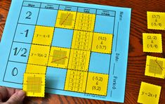 a person is holding up some yellow paper with numbers on it and four squares in the middle