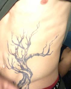 a man with a tree tattoo on his stomach