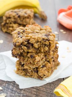 two oatmeal bars stacked on top of each other with bananas in the background