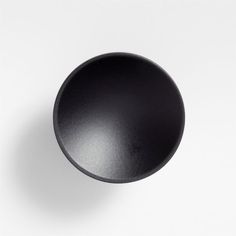 a black knob on a white wall