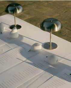 three lamps sitting on top of white sheets of paper