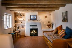 a living room filled with furniture and a fire place next to a wall mounted tv