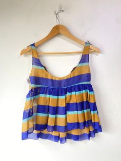 Vintage Miu Miu Striped Silk Top. Very delicate and so cute for summer! Features tan and blue stripes throughout with a purple and white cotton applique across the chest. Snap closures along the side. 100% silk, made in Italy. Marked a size 40, would best fit XS/S. In overall great vintage condition with some wear along the bust seam, refer to photos for more info. Approx. Measurements: Underarm to Underarm: 16" Length: 21" Summer Silk Tops For Vacation, Silk Summer Tops For Vacation, Silk Tops For Summer Vacation, Summer Beach Top With Vertical Stripes, Sleeveless Silk Beach Top, Sleeveless Silk Tops For Beach, Sleeveless Silk Tops For The Beach, Striped Tops For Summer Vacation, Fitted Tops With Vertical Stripes For Summer