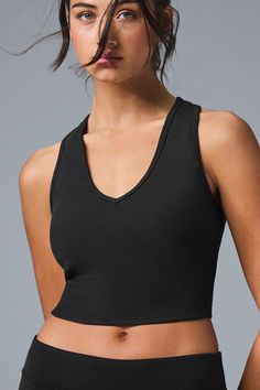 The Goddess Ribbed Cropped Racerback Tank has everything you want in a comfy, go-to top. Made in a soft ribbed knit, this tank features a V-neck, thick shoulder straps and cool racerback styling. Create so many versatile looks when you pair this with any signature Alo high-waist bottom. Comfy & lightweight ribbed fabric Cropped tank Light-to-medium support for studio & street Designed & uniquely fit to flatter every size Wear-tested by our in-house team for the perfect fit Black Sleeveless Tank Top With Ribbing, Black Ribbed Scoop Neck Tank Top, Black Stretch Ribbed Tank Top, Black Ribbed Racerback Tank Top, Seamless Alo Yoga Tops, Black Ribbed Tank Top For Yoga, Sleeveless Alo Yoga Athleisure Top, Alo Yoga Sleeveless Athleisure Top, Ribbed Tank Top For Workout