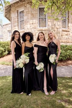 four women in black dresses posing for the camera