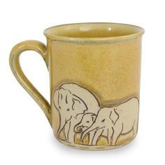 a yellow coffee mug with two elephants on the front and side, painted in gold