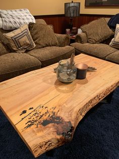 a wooden table sitting in the middle of a living room next to two couches