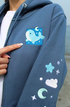 Drift along and let these cute little whale's tag along wherever you choose to go~ 🐋 Cotton with fleece interior🐋 Soft and cozy!🐋 Embroidered details on the front and sleeve detail🐋 Kamiaristudio logo tag on right sleeve and inside🐋Drawstrings have metal aglets🐋Unisex sizing ( see size chart for measurements) Model is 5'5" wearing a size S Have Metal, Logo Tag, Cayman Islands, Equatorial Guinea, Sleeve Detail, Mauritius, Laos, You Choose, Zip Up